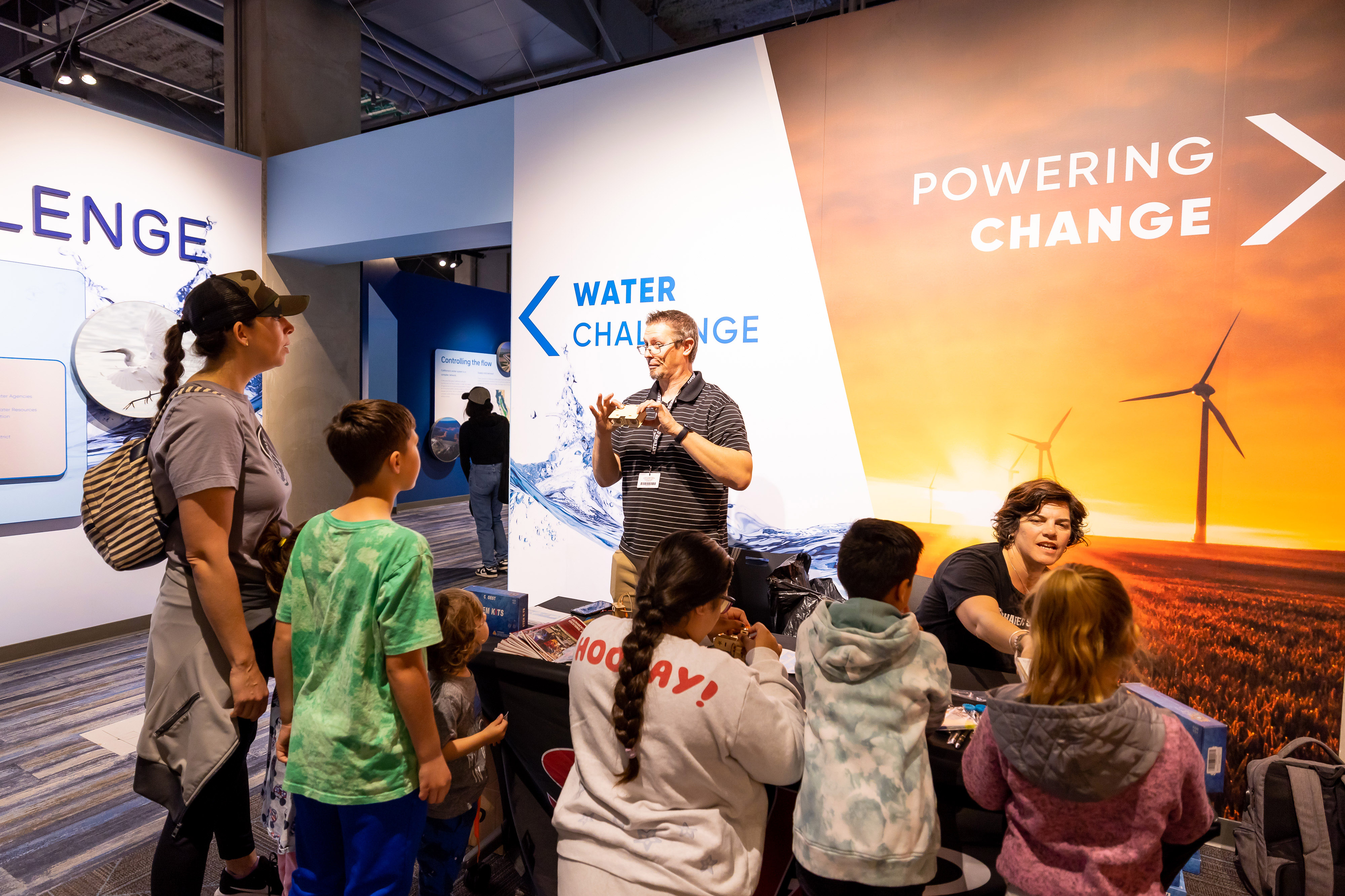 speaker explaining booth to guests