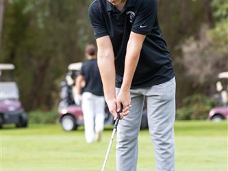 golf attendee teeing off