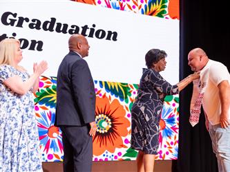 student shaking superintendent hand 