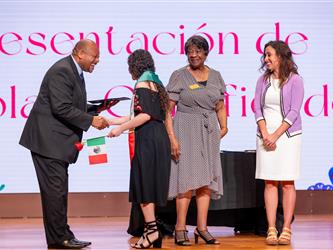 student on stage with diploma