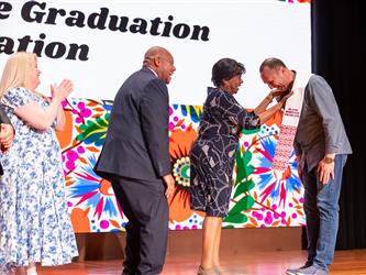 guest posing with gcc staff on stage