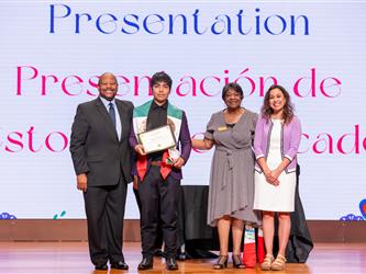 student on stage receiving diploma