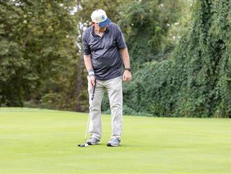golf attendee teeing off