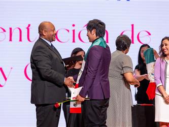 student on stage receiving diploma