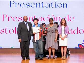 student on stage receiving diploma