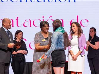 student on stage receiving diploma