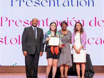 student on stage receiving diploma