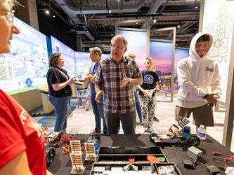 board member looking at robotics table 