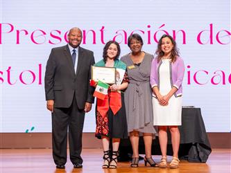 student on stage with diploma